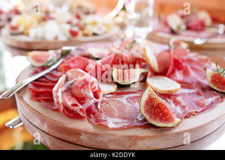 Italienische Antipasti und Vorspeisen. Board mit Scheiben Prosciutto, Salami, getrocknetes Schweinefleisch, Salami Schinken mit Kräutern. Stockfoto