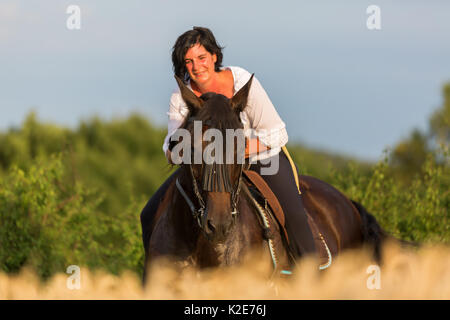 Porträt einer reifen Frau, die saß auf einem andalusischen Pferd Stockfoto
