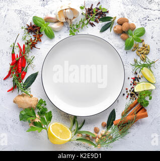 Kräuter und Gewürze Sammlung mit leeren Teller, Ansicht von oben. Stockfoto