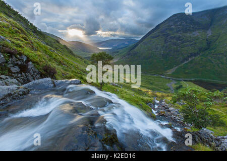 Wasserfall über Loch Achtriochtan mit Aonach Eagach im Hintergrund, Glen Coe, Highlands, Schottland, UK, August 2013. Stockfoto