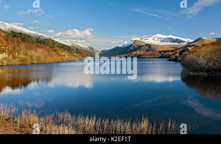 Llyn Padarn gesehen vom nördlichen Ende in Richtung LLanberis mit Mount Snowdon rechts im Hintergrund am späten Nachmittag Licht, Snowdonia, North Wales, UK, März. Stockfoto