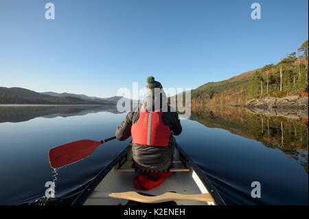 Kanufahren auf dem Loch Beinn a&#39; Mheadhoin, Scots Kiefern (Pinus sylvestris) am Ufer, Glen Affric, Highlands, Schottland. Stockfoto