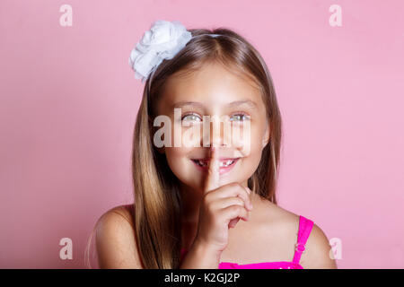 Kleines Mädchen mit einem Geheimnis. Kid halten den Finger in den Mund, als Stille oder geheime Zeichen Stockfoto