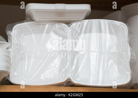 Kunststoff oder Papier weiß essen Boxen, Verpackung oder Platten in Plastiktüten verpackt auf einem Regal für Fast Food in der Speisekammer der Restaurant oder Cafe Stockfoto