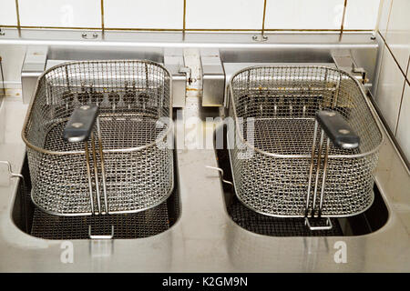 Zwei metall Friteusen mit Grips in der Küche von Restaurant, Bistro oder Cafe. Stockfoto