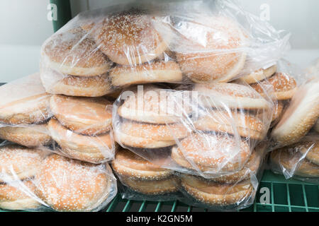 Raw gefrorene Brötchen für Burger der weißen Teig in transparenten Plastikbeuteln verpackt im Kühlschrank in der Küche des Restaurant oder Cafe. Stockfoto