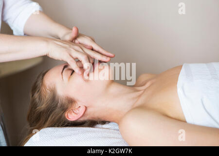 Junge hübsche Frau Gesicht Massage oder einer Schönheitsbehandlung im Spa Salon Stockfoto