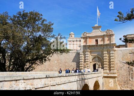 Touristen überqueren Sie die Fußgängerbrücke zum Stadttor und Stadtzentrum, Mdina, Malta, Europa. Stockfoto