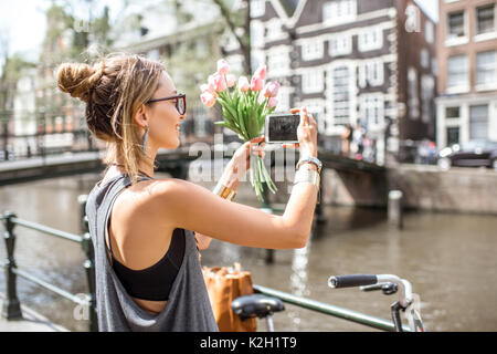 Frau mit Fahrrad in Amsterdam City Stockfoto