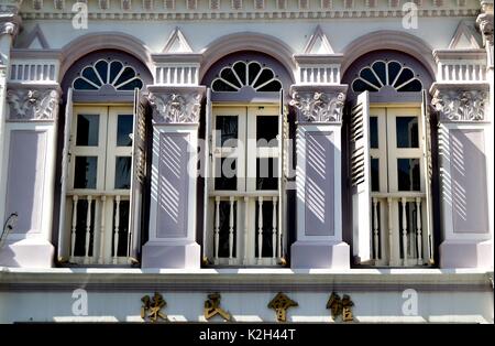 Traditionelle shop Haus außen mit weiße hölzerne Lamellenfensterläden, gewölbte Fenster und Balkon aus Holz in der Chinatown von Singapur Stockfoto