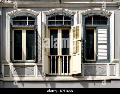 Traditionelle shop Haus außen mit grauen und weißen hölzerne Lamellenfensterläden, gewölbte Fenster und Balkon aus Holz in der Chinatown von Singapur Stockfoto