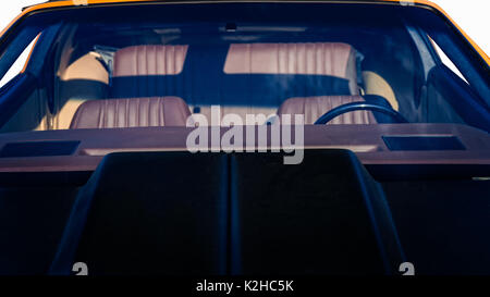 Schwarze Haube, staubige Windschutzscheibe und Leder Sitze im Fahrgastraum eines Sportwagens. Vor weißem Hintergrund. Stockfoto