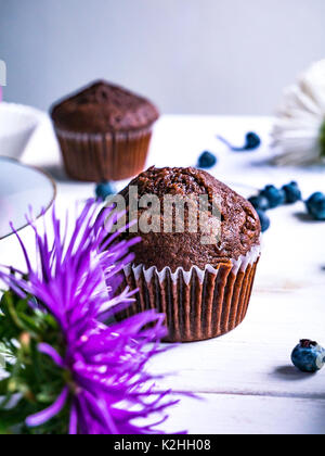 Close-up von Schokolade Muffins auf einem weißen Tisch mit verschiedenen Dekorationen. Stockfoto