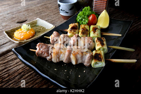 Butabara Yakitori oder Japanischen bacon Schweinefleisch grillen, mit Salz und Sauce servieren in izakaya Restaurant. Stockfoto