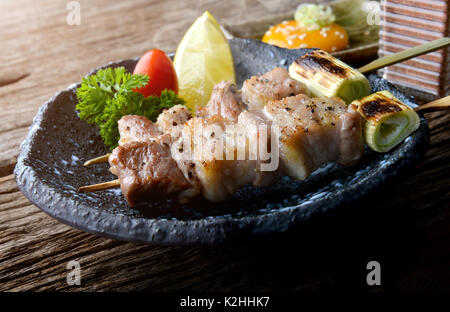 Butabara Yakitori oder Japanischen bacon Schweinefleisch grillen, mit Salz und Sauce servieren in izakaya Restaurant. Stockfoto
