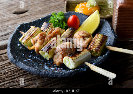 Nekima Yakitori oder Japanischen Huhn und Zwiebel in Bambus Spieße vom Grill mit Holzkohle Feuer dienen in izakaya Restaurant. Stockfoto
