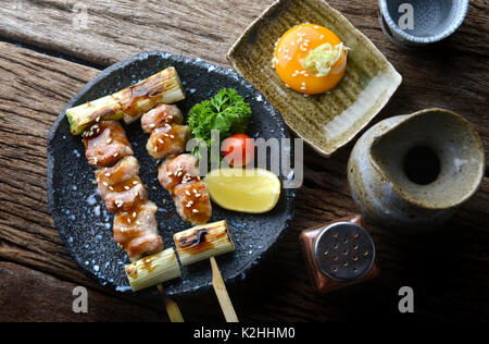 Butabara Yakitori oder Japanischen bacon Schweinefleisch grillen, mit Salz und Sauce servieren in izakaya Restaurant. Stockfoto