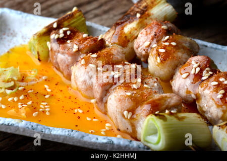 Butabara Yakitori oder Japanischen bacon Schweinefleisch grillen, mit Salz und Sauce servieren in izakaya Restaurant. Stockfoto