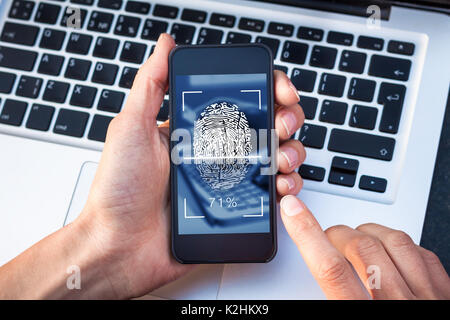 Scannen von Fingerabdrücken auf dem Smartphone Bildschirm mit dem Finger berühren Biometrische digitale Scanner, Identitätsprüfung, cybersecurity access control Stockfoto