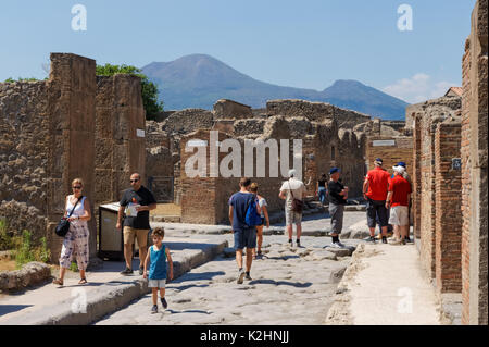 Touristen, die römischen Ruinen von Pompeji, mit dem Vesuv im Hintergrund, Italien Stockfoto