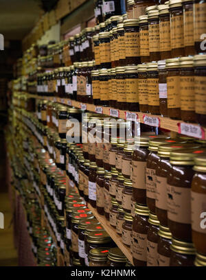 Reihen von Apple Butter und Marmelade auf Old Country Store Shelves - Canning Essen Lagerungsart Metall Canning Deckel auf Gläsern sind gekocht bis abgedichtet Stockfoto