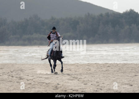 SONGKHLA THAILAND - 18. Februar: Unbekannt cowboy Show am Strand galoppiert das Pferd am 18. Februar 2017 in Songkhla, Thailand. Stockfoto