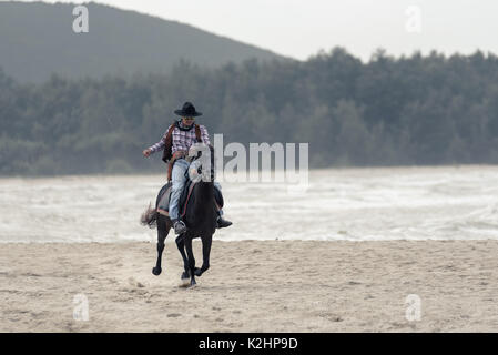 SONGKHLA THAILAND - 18. Februar: Unbekannt cowboy Show am Strand galoppiert das Pferd am 18. Februar 2017 in Songkhla, Thailand. Stockfoto