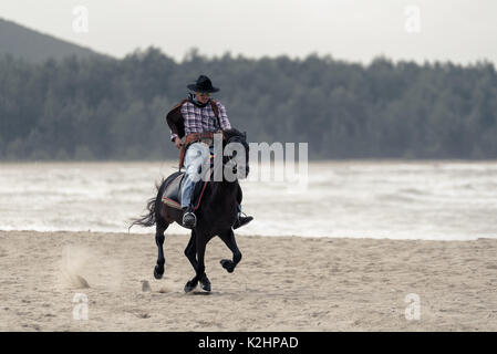 SONGKHLA THAILAND - 18. Februar: Unbekannt cowboy Show am Strand galoppiert das Pferd am 18. Februar 2017 in Songkhla, Thailand. Stockfoto