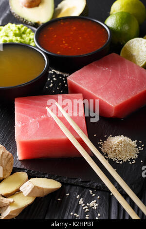 Japanische Küche: roher Thunfisch Steak mit Zutaten zum Kochen close-up auf dem Tisch. Vertikale Stockfoto