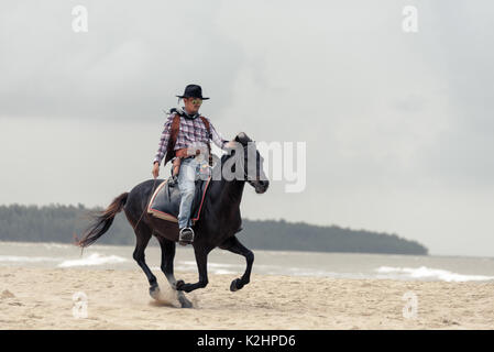 SONGKHLA THAILAND - 18. Februar: Unbekannt cowboy Show am Strand galoppiert das Pferd am 18. Februar 2017 in Songkhla, Thailand. Stockfoto