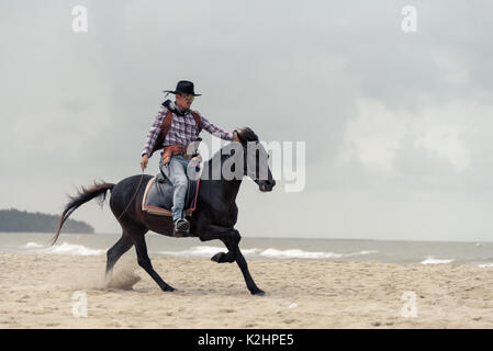 SONGKHLA THAILAND - 18. Februar: Unbekannt cowboy Show am Strand galoppiert das Pferd am 18. Februar 2017 in Songkhla, Thailand. Stockfoto