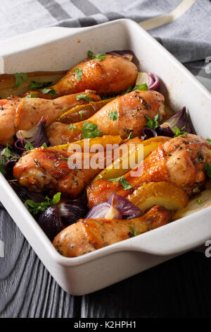 Hähnchenschenkel gebacken mit roten Zwiebeln und Grüns in Honig - Sojasauce close-up in einer Schale zum Backen. Vertikale Stockfoto
