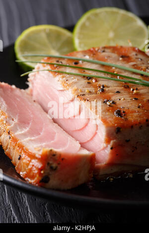 Gegrillte Paprika Thunfisch Steak mit Kalk Makro auf einem Teller. Vertikale Stockfoto