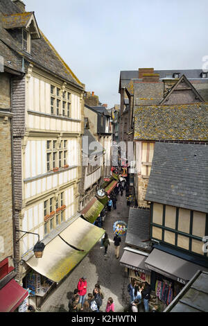 Touristen zu Fuß durch die engen Gassen der mittelalterlichen Stadt in Mont Saint-Michel in der Normandie, Frankreich. Stockfoto