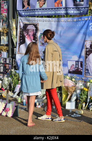 Leute schauen auf Blumen und Würdigungen zum 20. Jahrestag des Todes von Diana, Prinzessin von Wales, außerhalb der Kensington Palace, London. Stockfoto