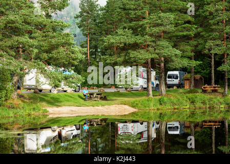 Valdres, Norwegen - 16. August 2017: Reisedokumentation der rest stop Bereich für Autofahrer neben dem Fluss Otra. Sitzende Person durch das ruhige Fluss mit Ca Stockfoto