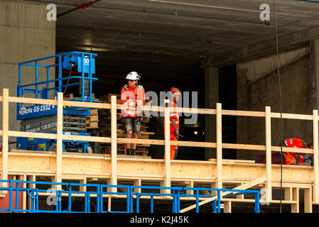 Kristiansand, Norwegen - 16. August 2017: Reisedokumentation der Arbeitnehmer, die sich eine Pause, hängen auf dem Geländer einer Baustelle in der Stadt. Stockfoto