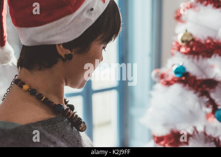 Junge Frau zu Hause vorbereiten Weihnachtsbaum - Weihnachten, Urlaub, Winter Konzept Stockfoto