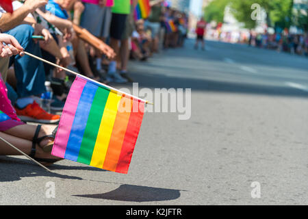 Gay Regenbogen Flagge in Montreal Gay Pride Parade 2017 mit unscharfen Zuschauer im Hintergrund Stockfoto