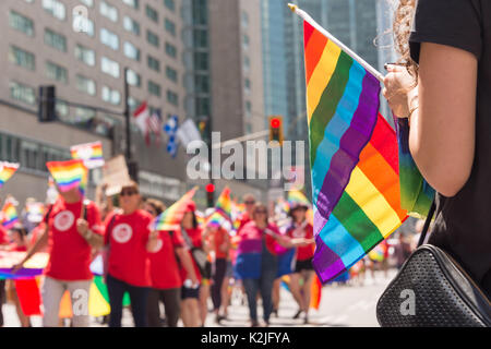 Gay Regenbogen Flagge in Montreal Gay Pride Parade 2017 mit unscharfen Zuschauer im Hintergrund Stockfoto