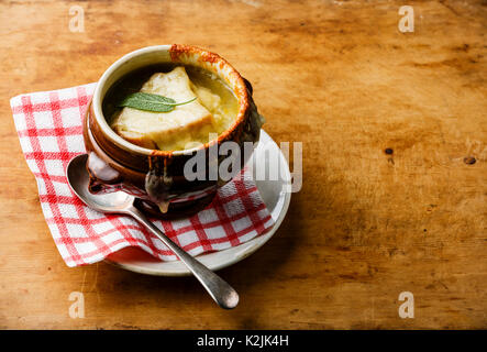 Authentische französische Zwiebelsuppe mit getrockneten Brot und Cheddar in Schüssel auf Holz- Background Copy space Stockfoto