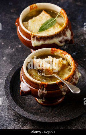 Französische Zwiebelsuppe mit getrockneten Brot und Cheddar Käse in der Schüssel auf dunklem Hintergrund close-up Stockfoto