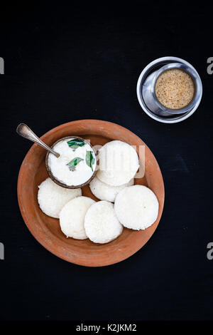 Ein traditionelles South Indian Frühstück mit frischem gedämpft Indischen Untätig (Idli/Reis Kuchen) serviert mit Kokos Chutney und Filter Kaffee Stockfoto