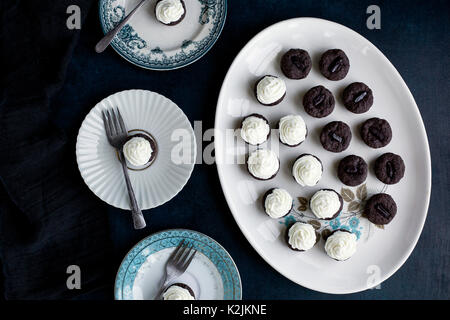 Brownie Bites mit Orange Blossom Mascarpone Zuckerguss. Auf dunkelblauem Hintergrund fotografiert. Stockfoto