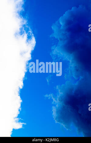 Kontrast zwischen weißen und dunklen blauen Wolken, immer noch regnerischen nach einem heftigen Gewitter in einem klaren, blauen Himmel Stockfoto