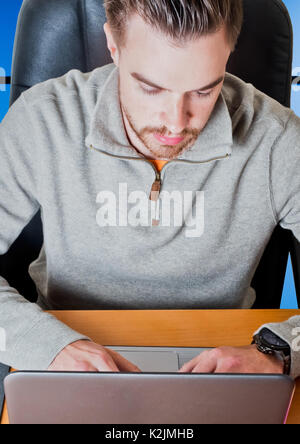 Jungen attraktiven Mann am Computer im Büro mit Blue Panel an der Rückseite des Stuhl Stockfoto