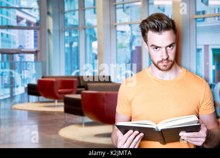 Jungen attraktiven Mann im Amt mit Buch Stockfoto