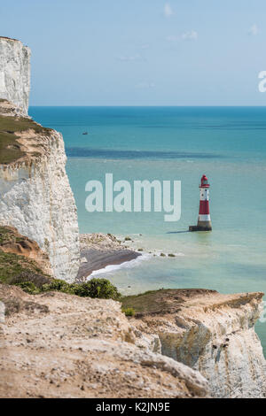 Rot-weiß gestreifte Beachy Head Lighthouse unter sieben Schwestern weißen Felsen sitzt. Stockfoto