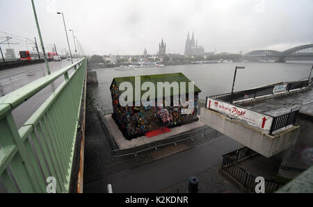 Köln, Deutschland. 31 Aug, 2017. Die "Rettung der Welt" Hotel von Performance Künstler HA Schult kann am Rhein in Köln, Deutschland, 31. August 2017 zu sehen. Die Skulptur ist eine leicht zugängliche Haus gemacht und mit "Papierkorb" eingerichtet. Foto: Henning Kaiser/dpa/Alamy leben Nachrichten Stockfoto