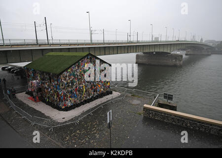 Köln, Deutschland. 31 Aug, 2017. Die "Rettung der Welt" Hotel von Performance Künstler HA Schult kann am Rhein in Köln, Deutschland, 31. August 2017 zu sehen. Die Skulptur ist eine leicht zugängliche Haus gemacht und mit "Papierkorb" eingerichtet. Foto: Henning Kaiser/dpa/Alamy leben Nachrichten Stockfoto